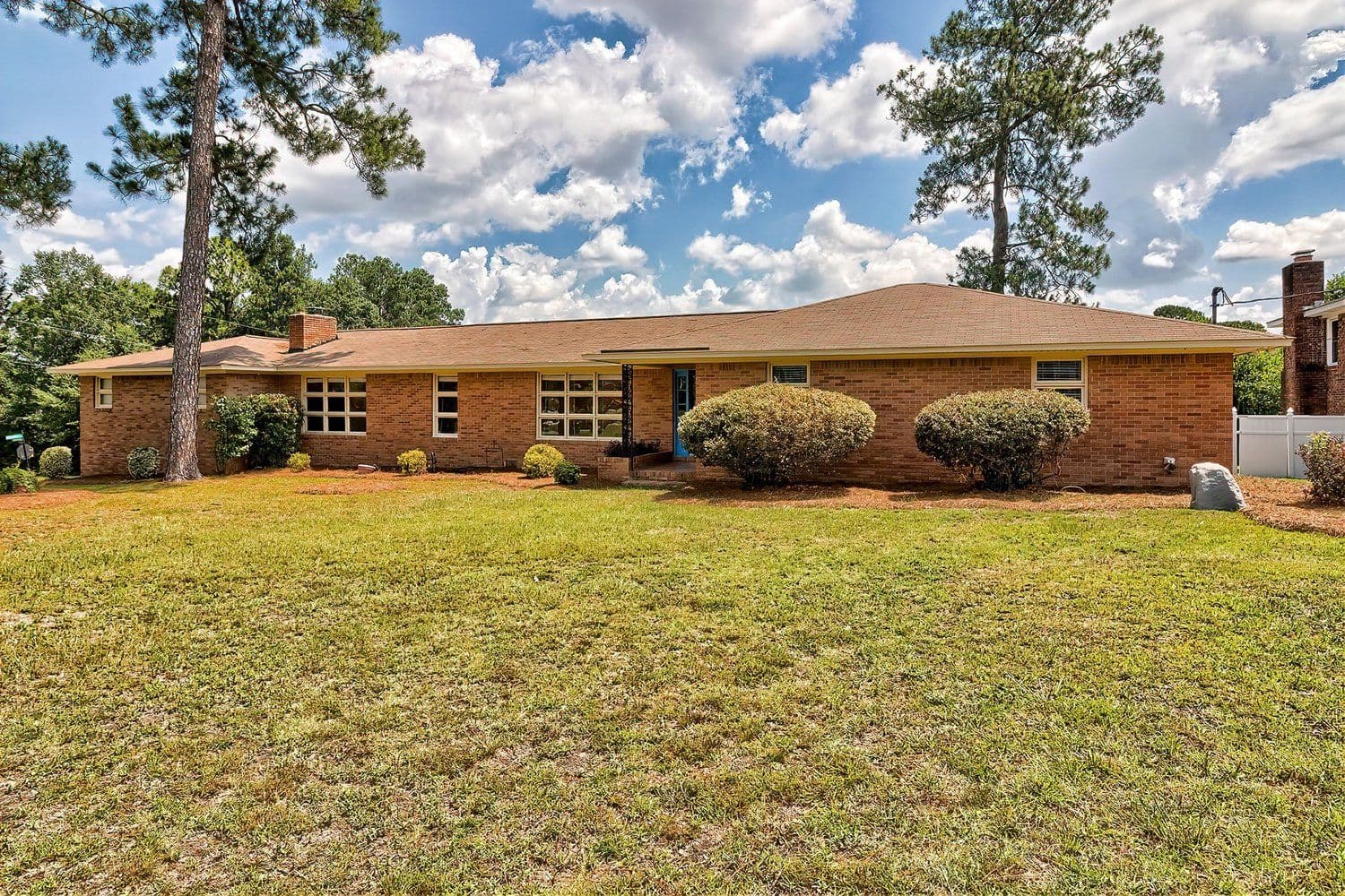 Brick craftsman home with a covered front porch, a sidewalk, and an American flag