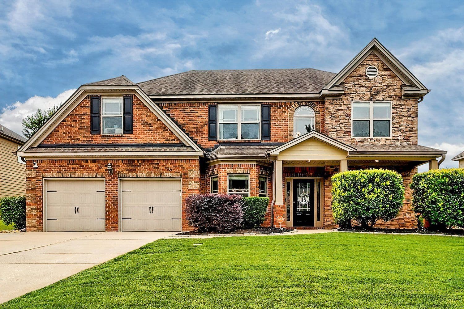 Multi-gabled brick house with a three-car garage