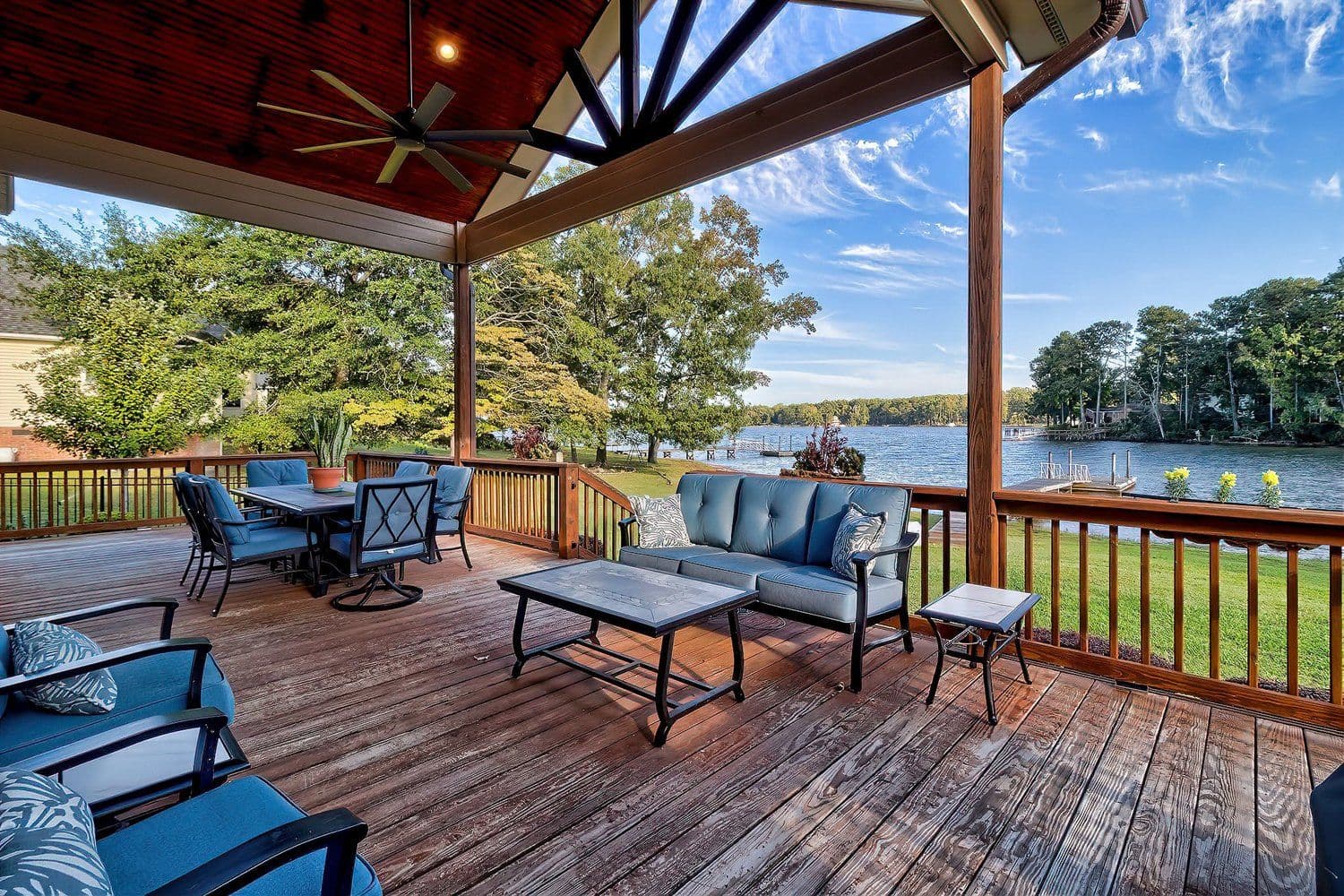 Covered outdoor porch with sofa and chairs looking out over the water