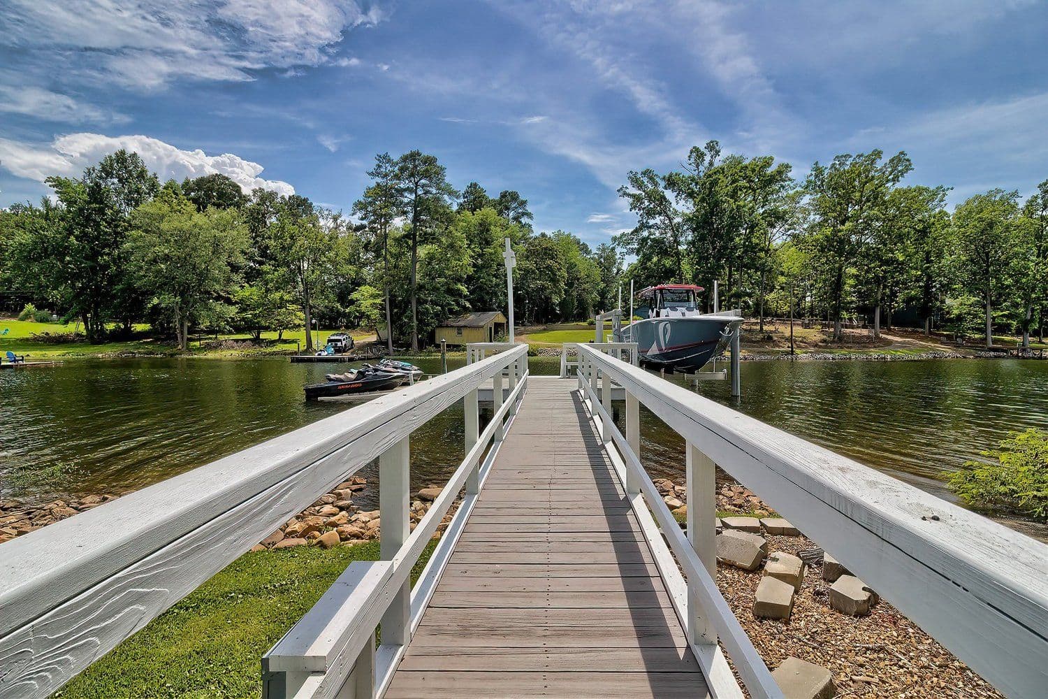 Long modern walkway dock leading toward a wooded shoreline