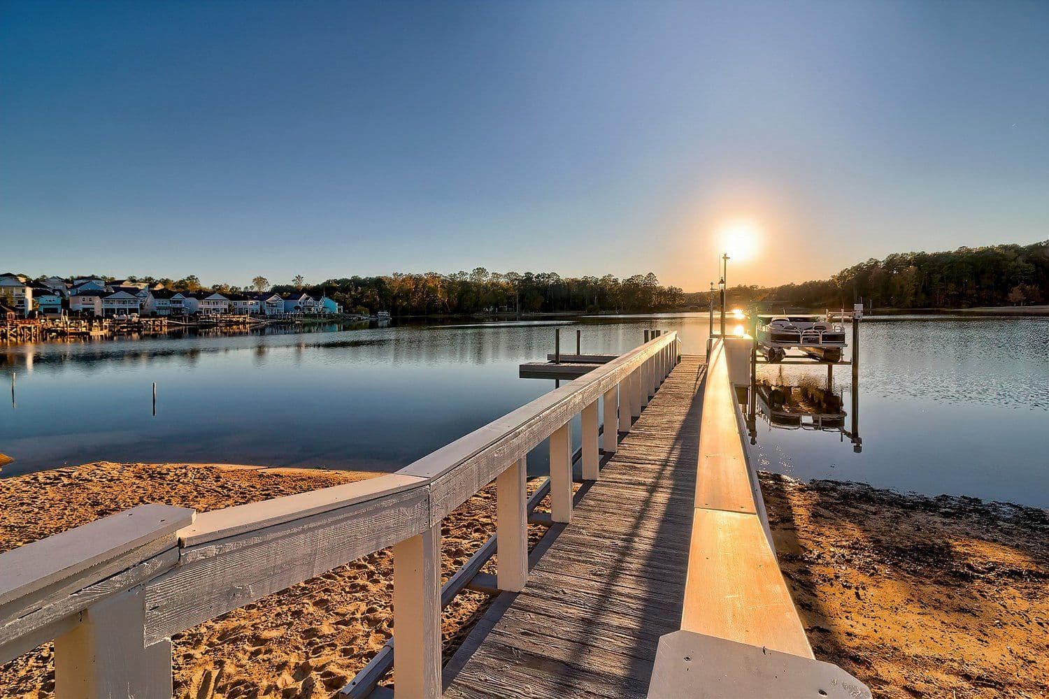 Long wooden dock extending into the calm lake at sunset