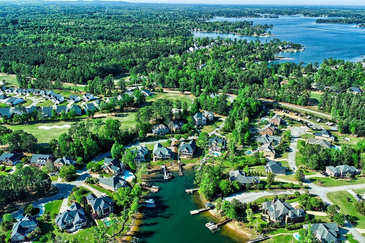 Lush aerial of a neighborhood along a winding waterway