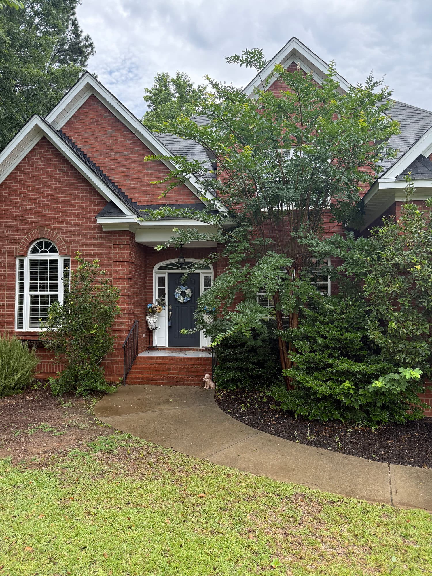 A brick entry with an arched window and a walkway