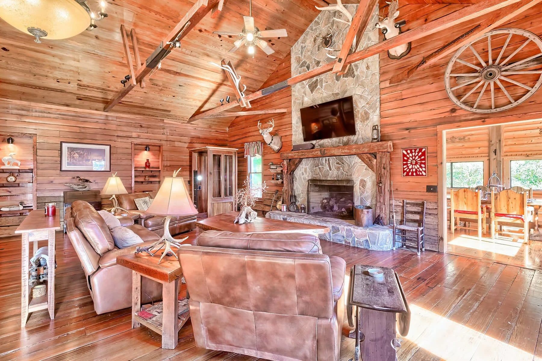 A lodge living room with a stone fireplace and wood beams