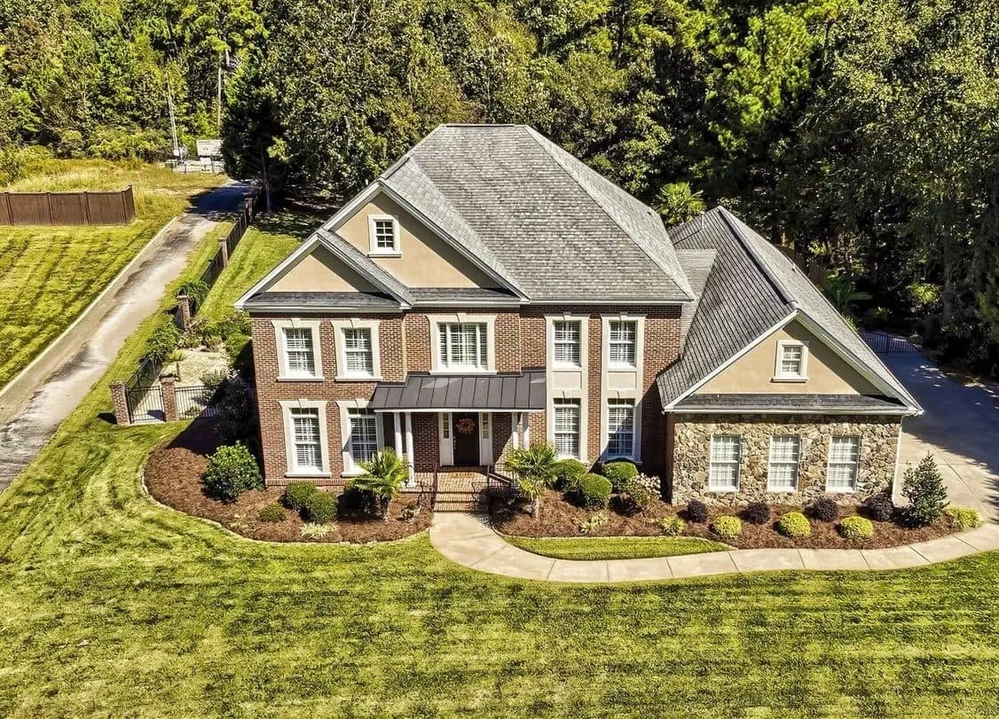A brick and stone house on a wooded lot