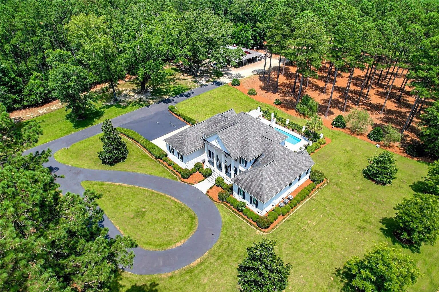 Aerial of a white home with a pool and pines in Batesburg-Leesville, South Carolina