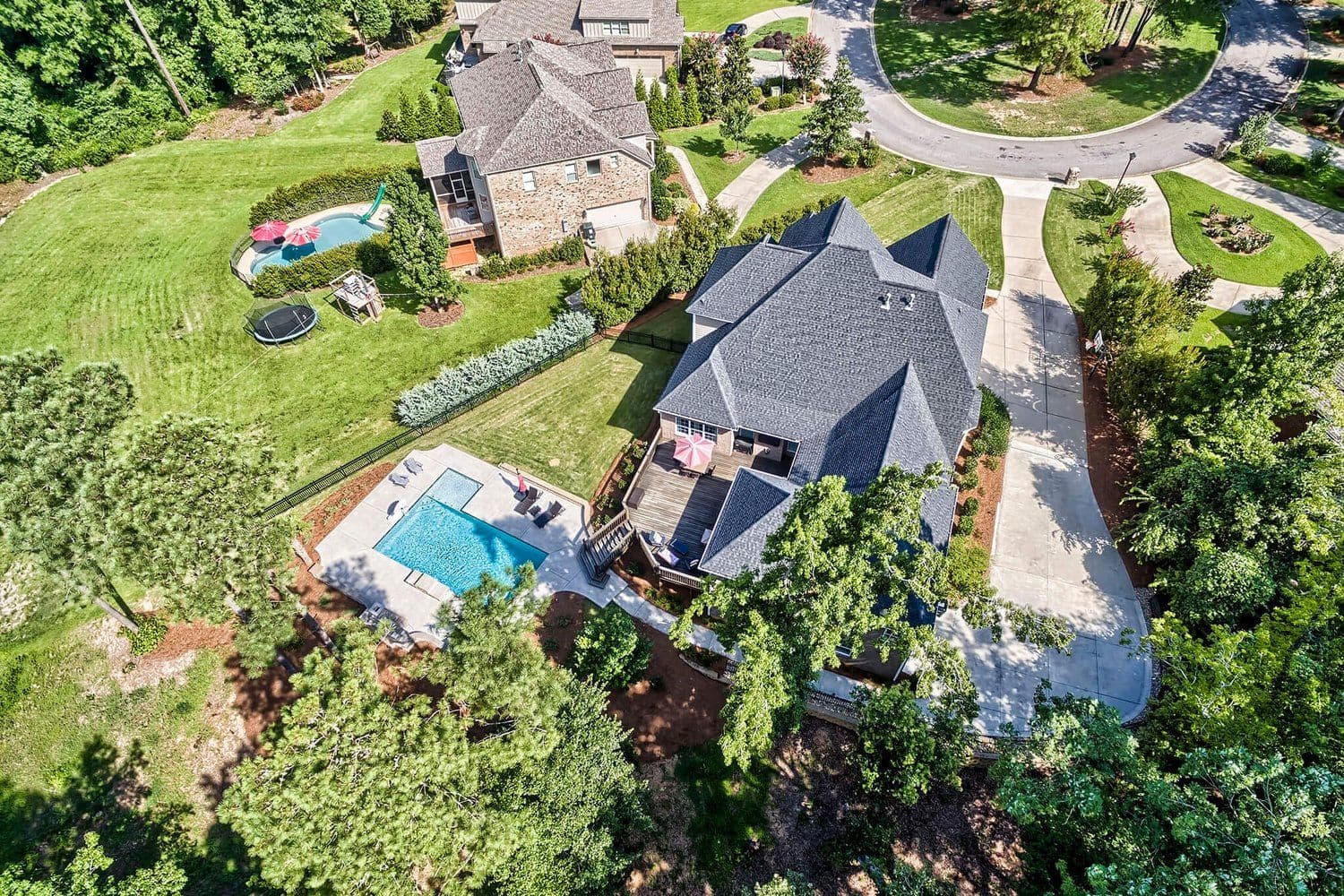 Aerial of a large property with a backyard pool and wide driveway