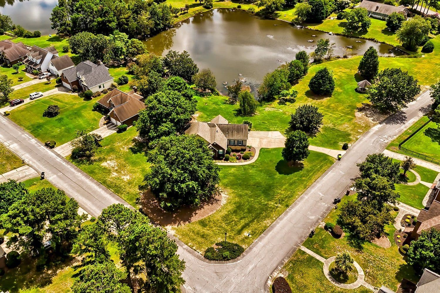 Aerial of a suburban cul-de-sac with a community pond