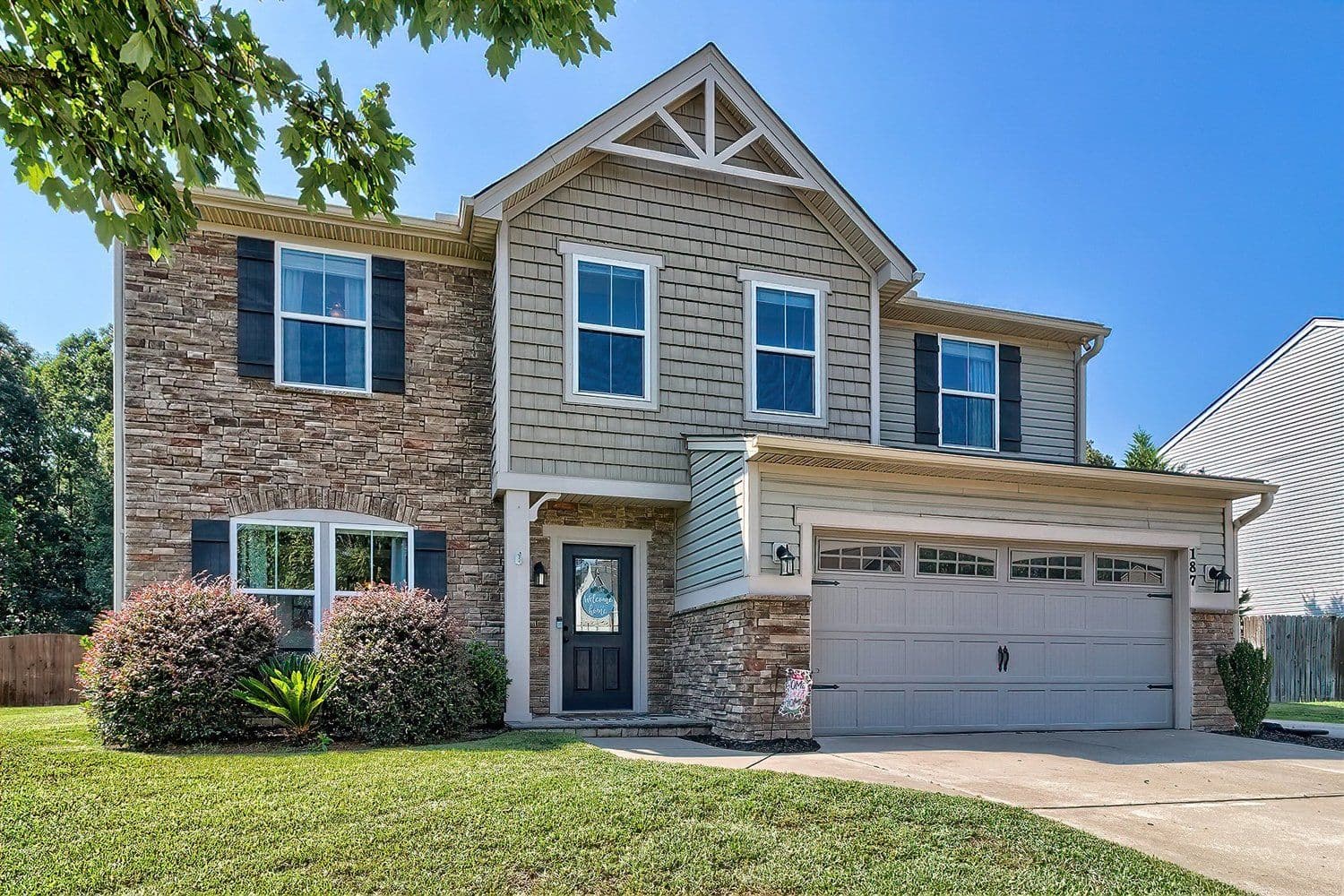 Beige and brick suburban home with a two-car garage