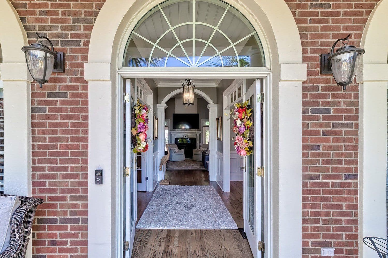 Brick entrance with an arched white doorway and lanterns