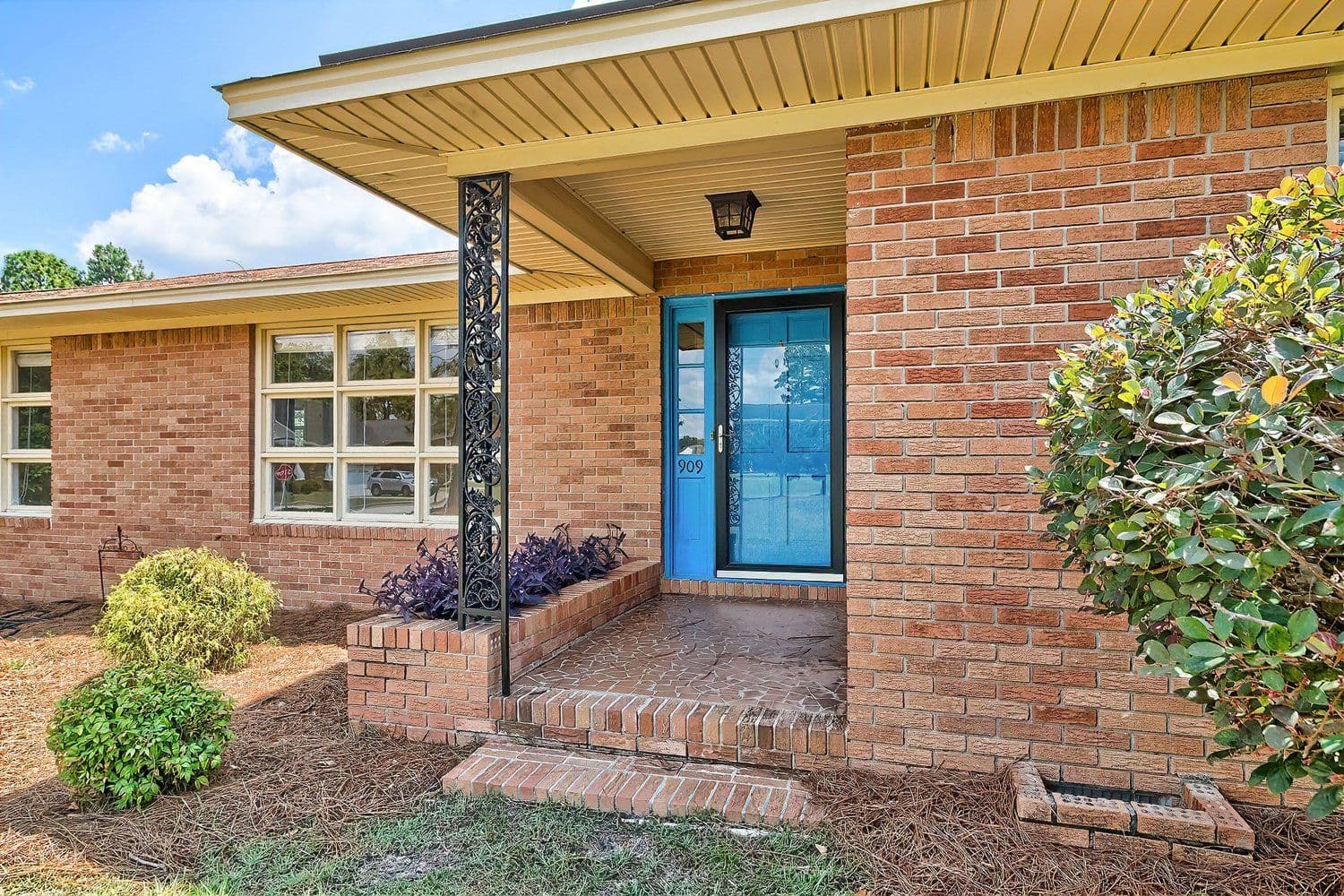 Brick home entrance with a bright blue front door