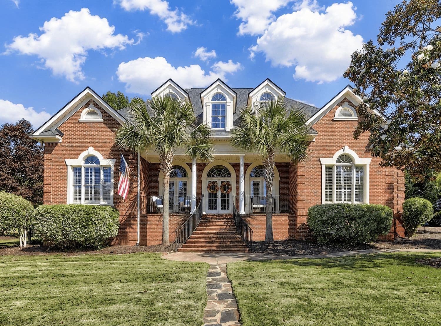 Brick home with palm trees and a wide lawn