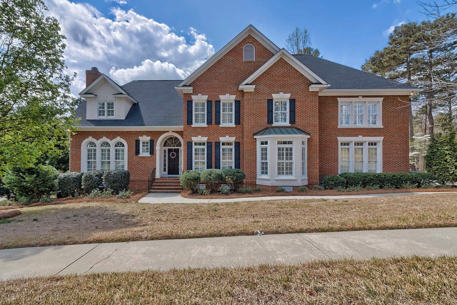 Classic two-story red brick colonial with white trim