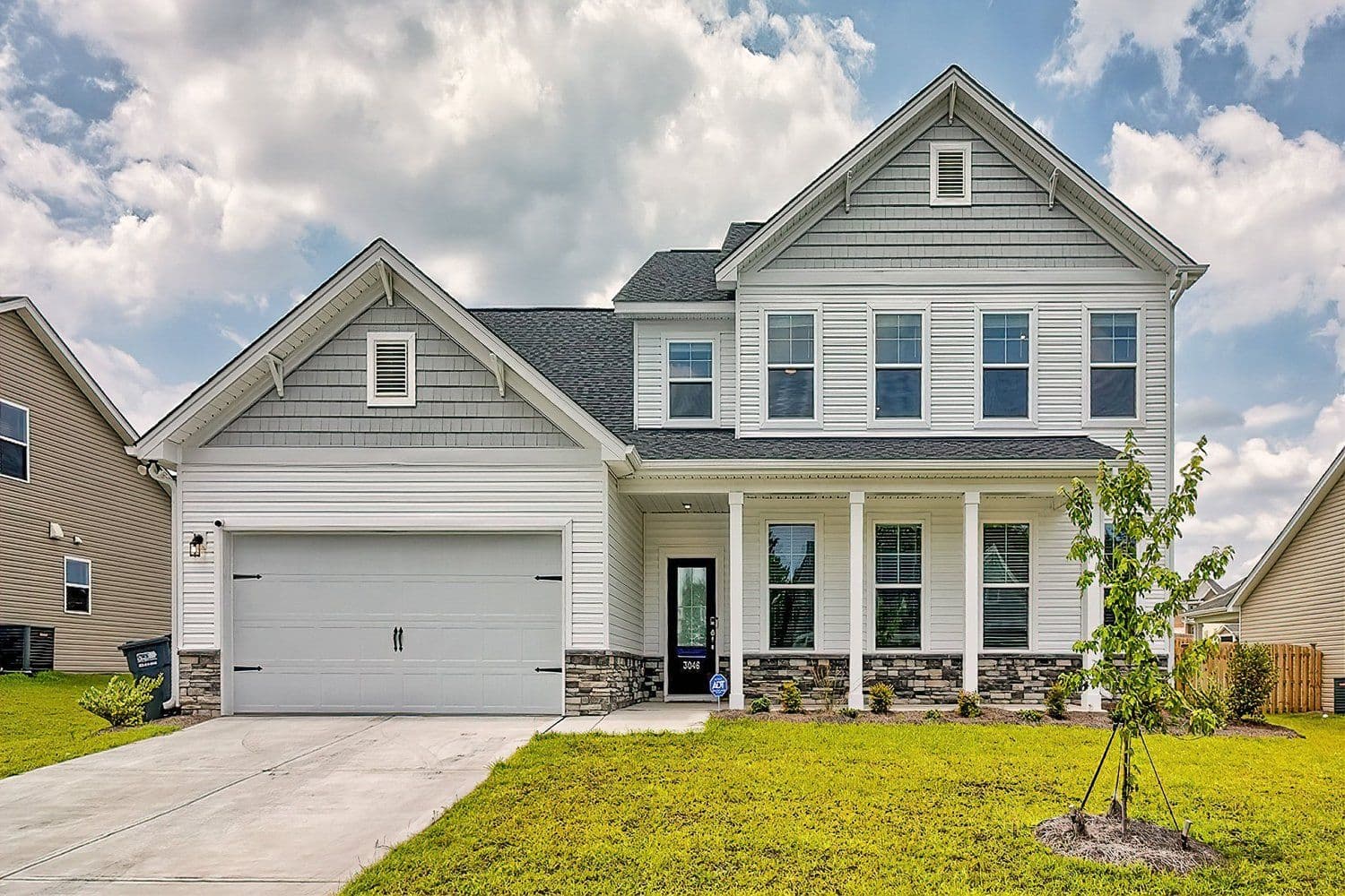 Craftsman home with stone accents, a covered front porch, and a landscaped walkway