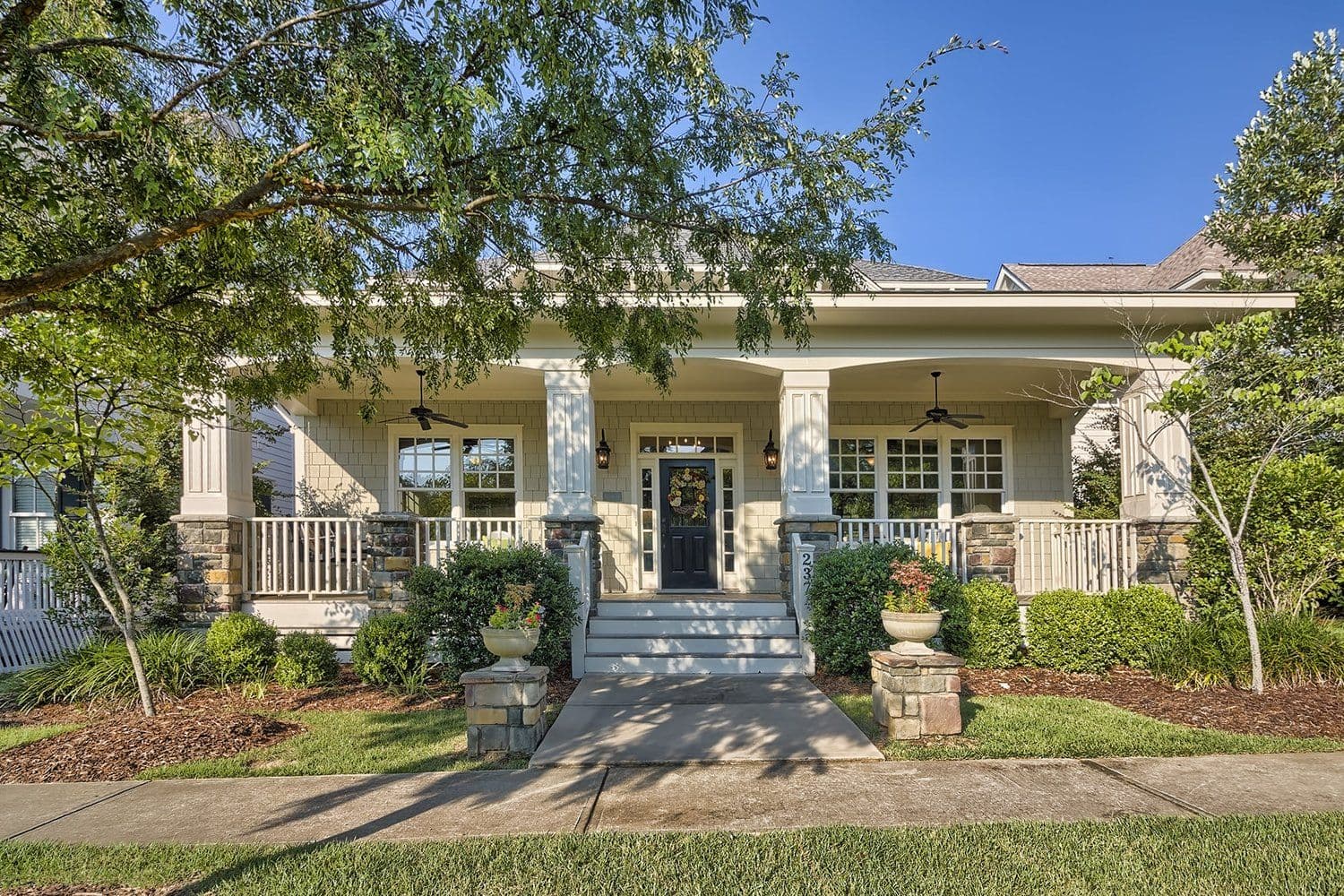 Craftsman-style home with a large front porch and stone pillars