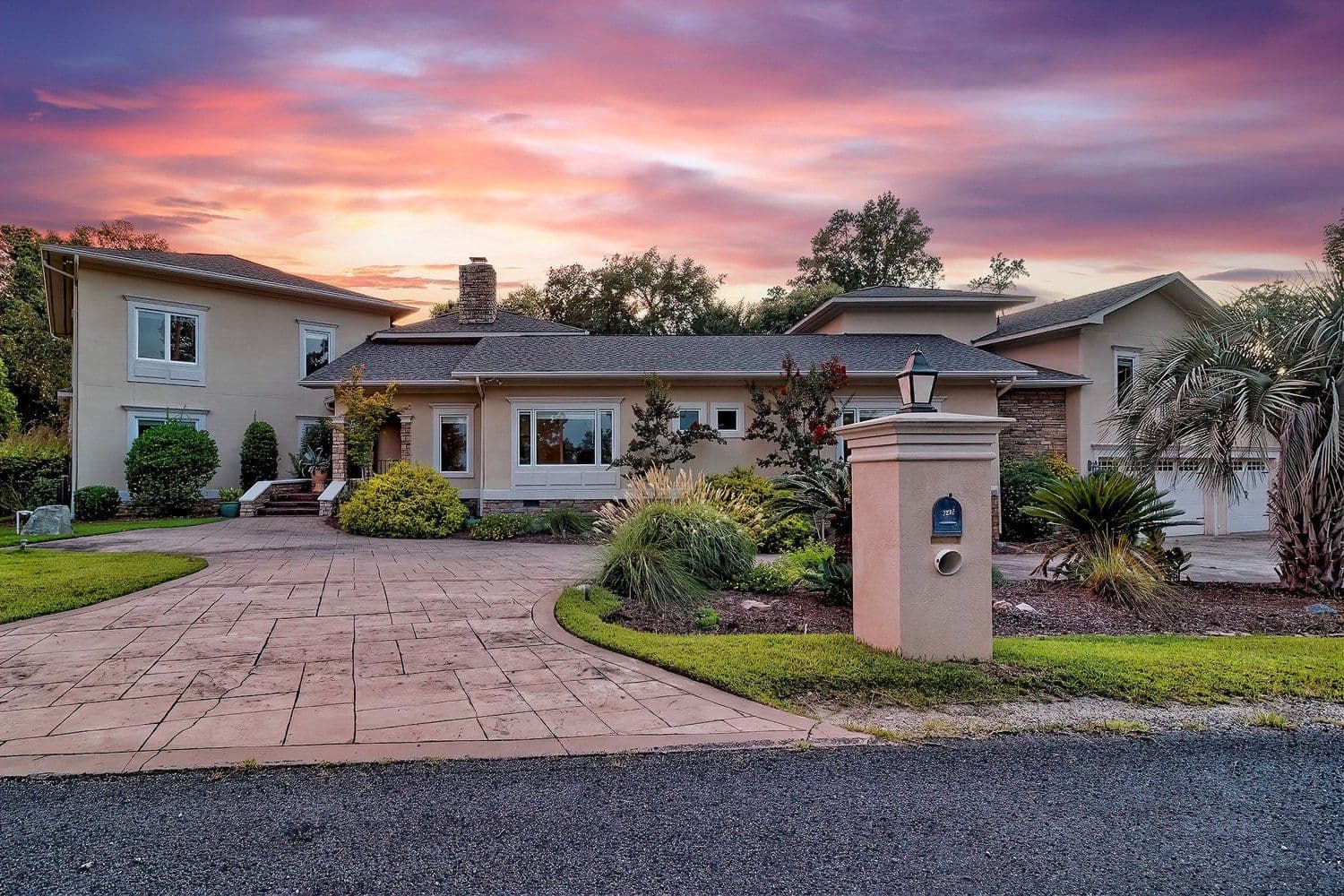 Driveway and front entrance of a house at a pink sunset