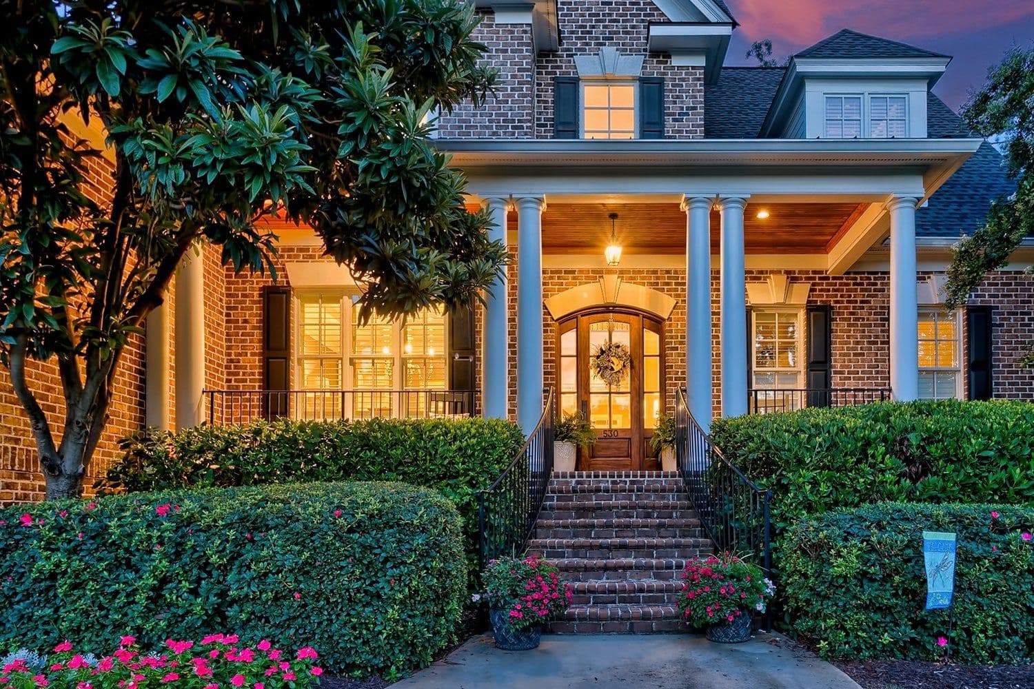 Front entrance of a home at night with warm lighting and columns