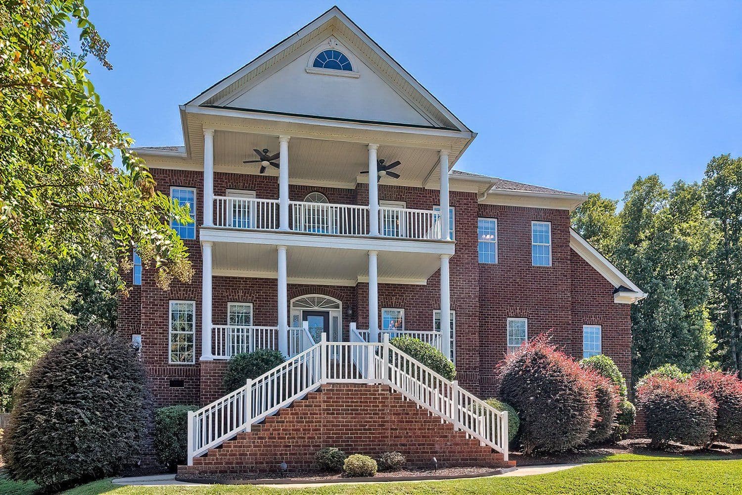 Grand three-story house with white columns and balconies