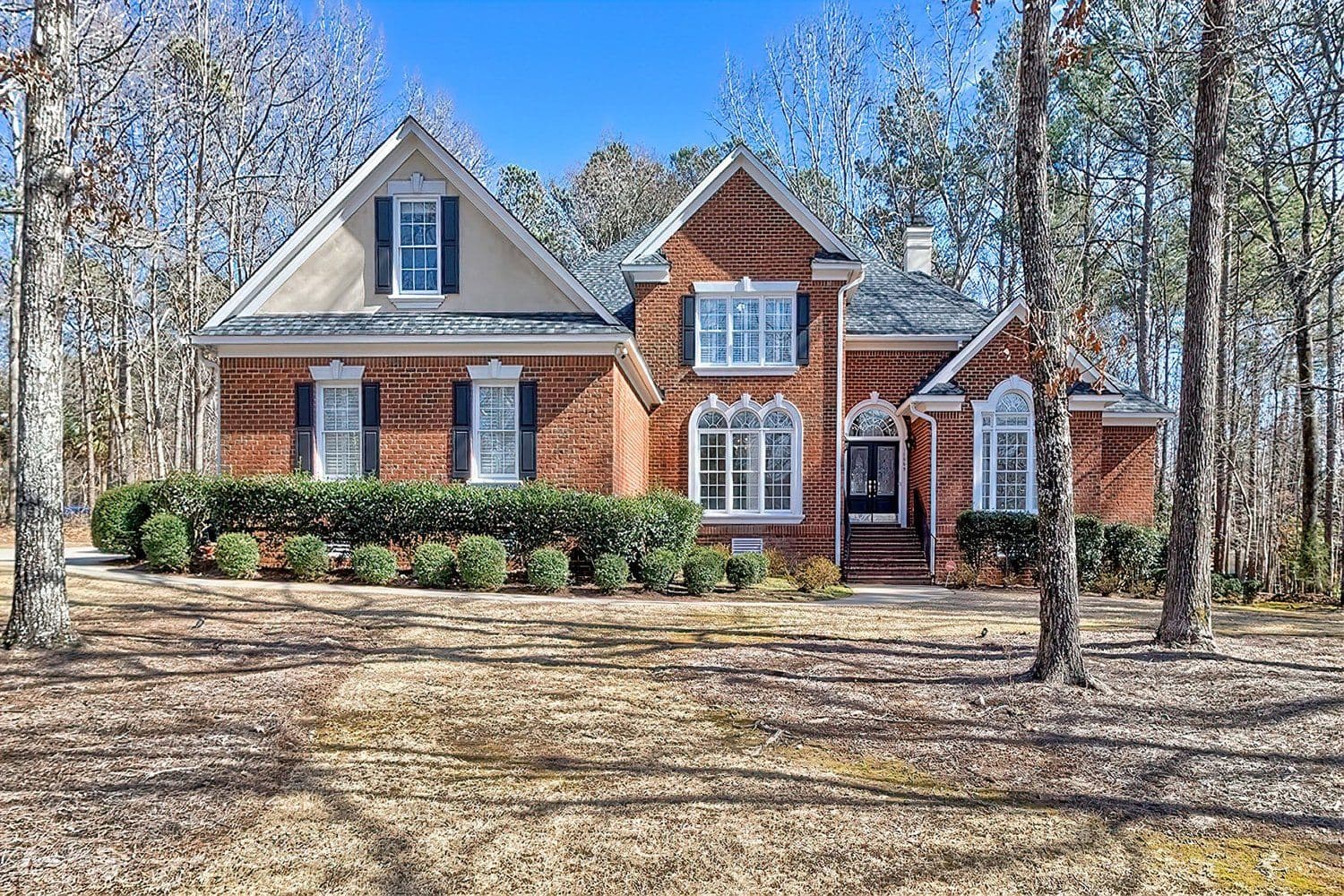 Large two-story brick house surrounded by trees