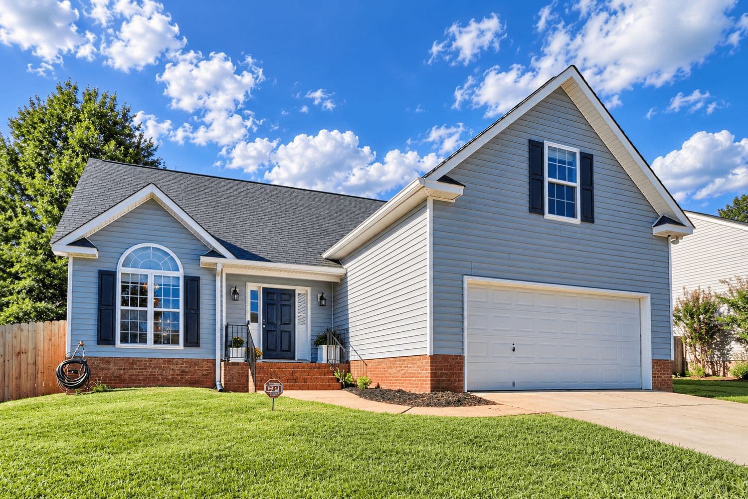 Single-story light blue house with white trim and a two-car garage