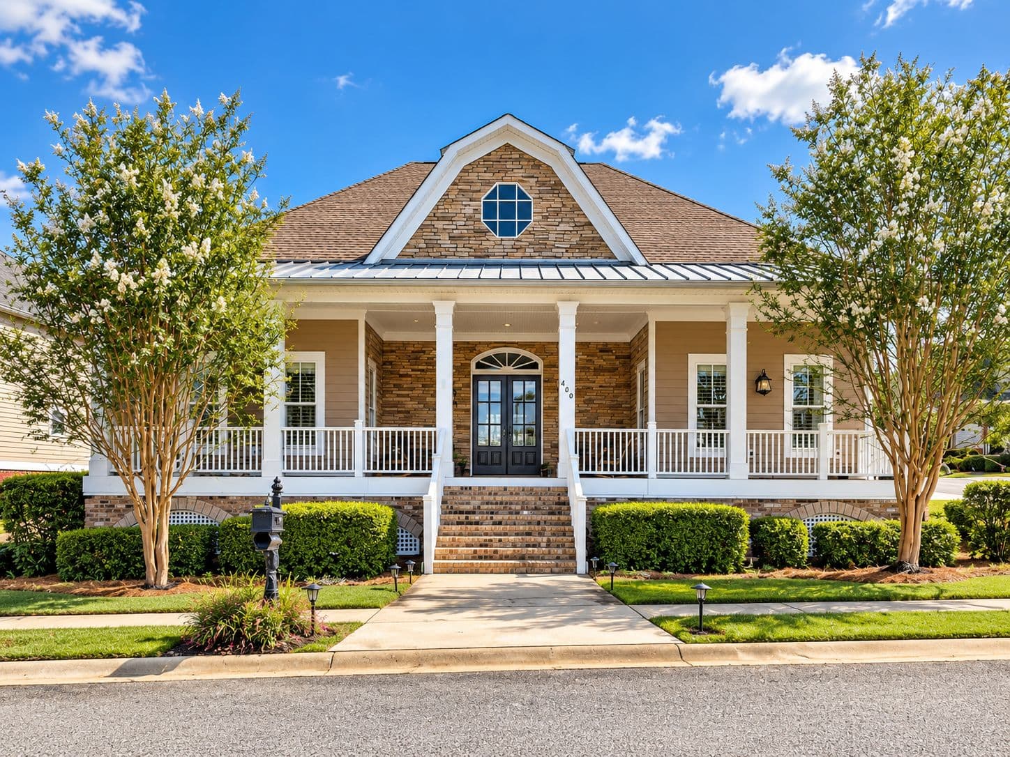 Single-story light-colored home with a central gable and wide porch