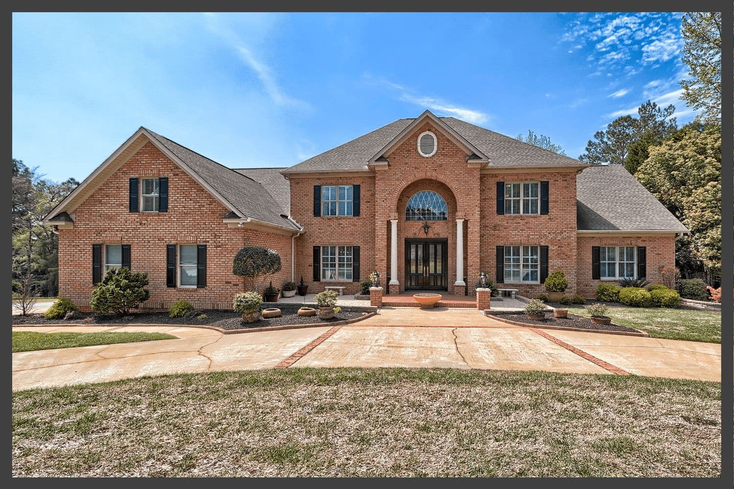 Sprawling red brick home with a circular driveway
