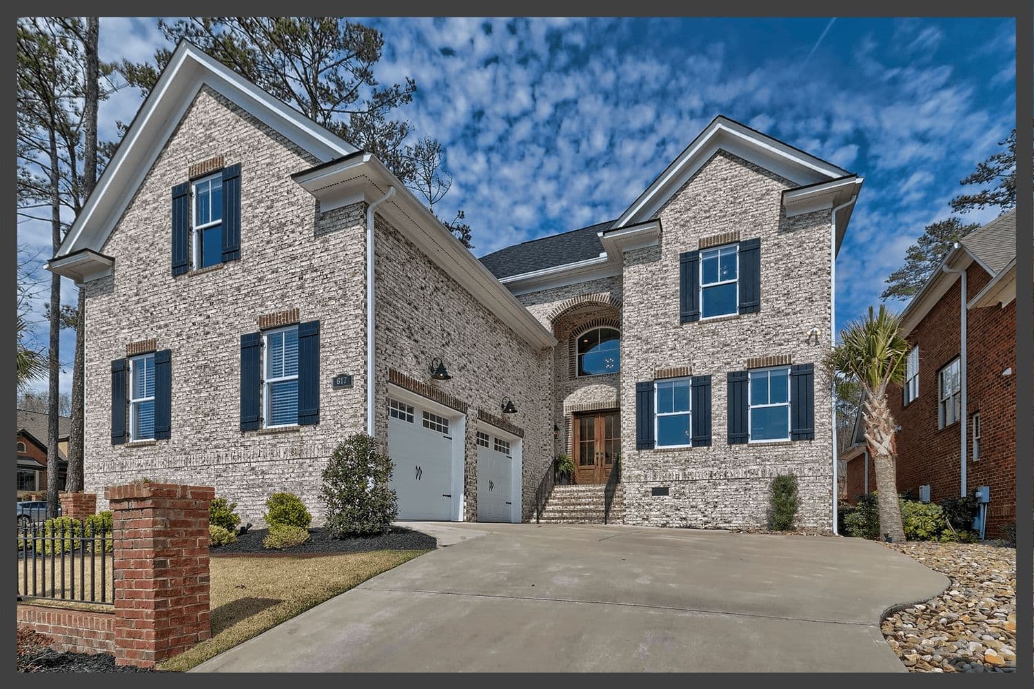 Two-story house with light brick, grey stone and a side-entry garage