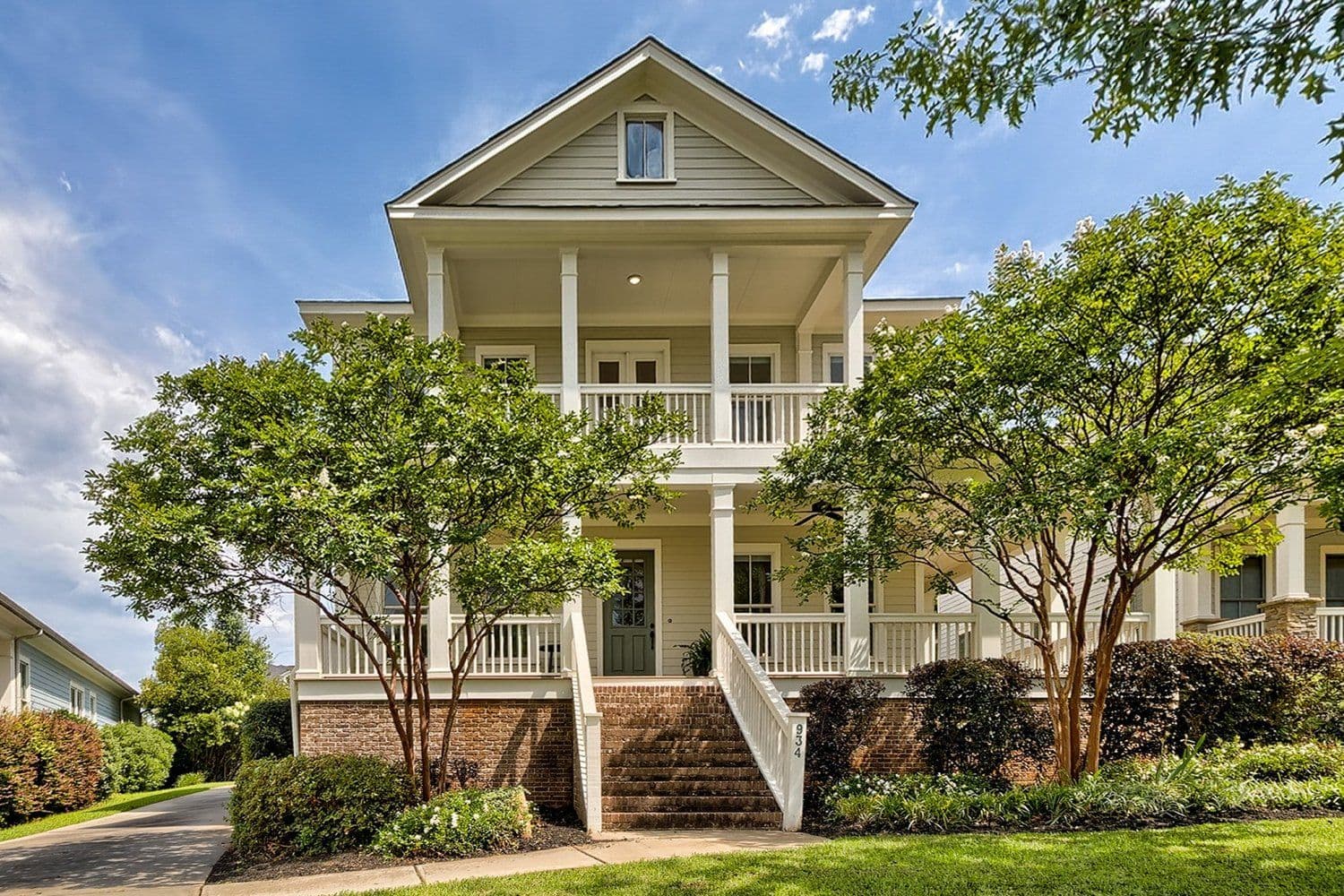 Yellow coastal-style home with white trim and a front porch