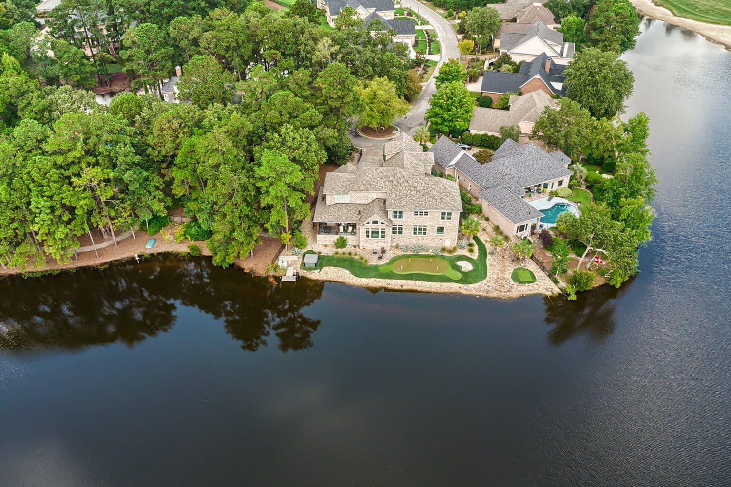 Aerial of a lakefront home and dock among trees