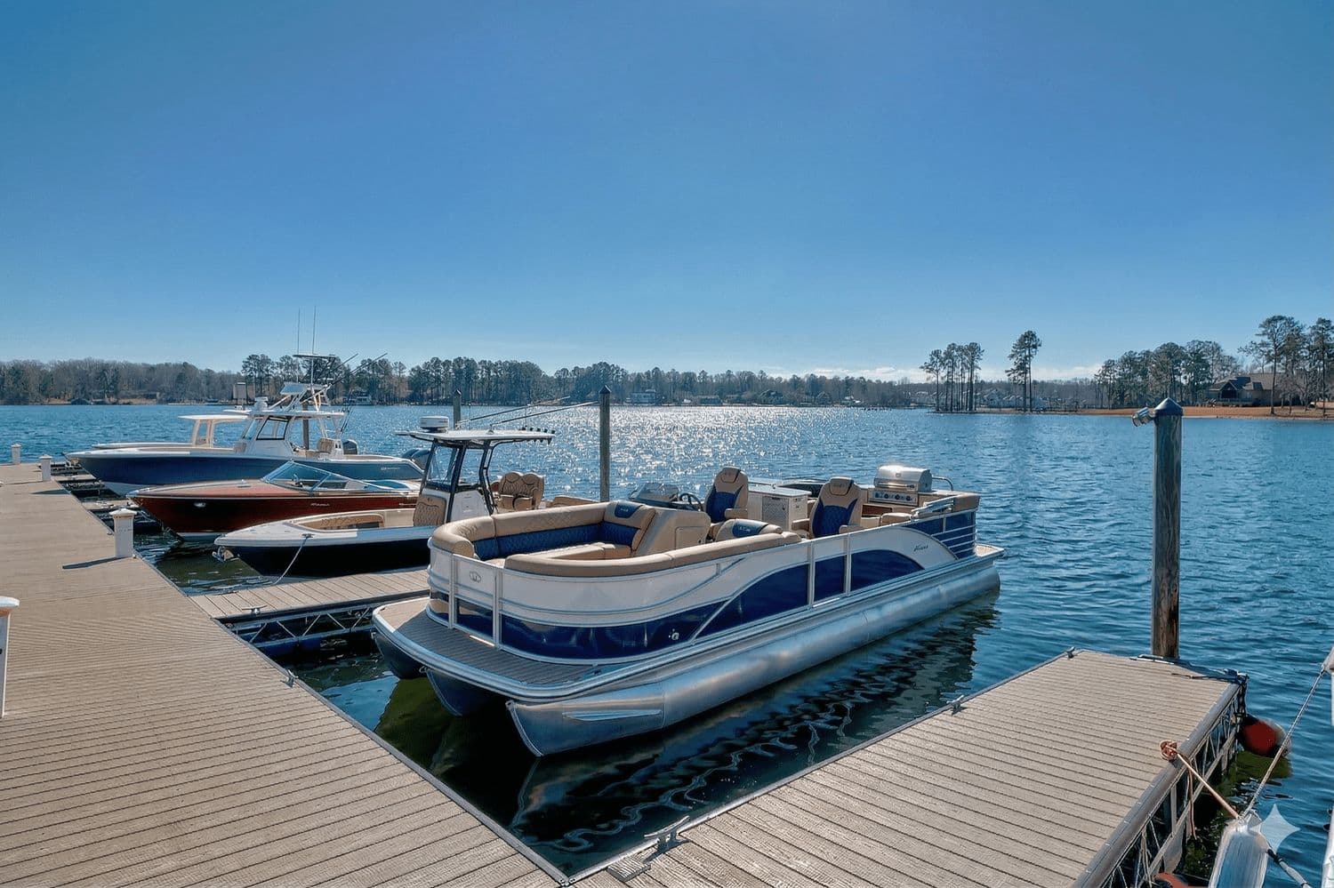 Pontoon boats parked in their slips seen from a dock