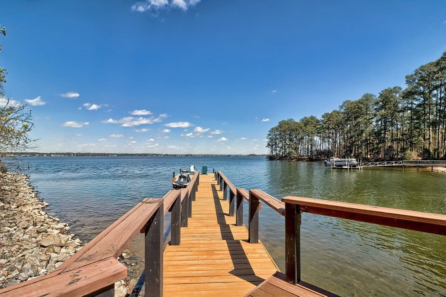 View from the end of a wooden dock over a wide calm lake