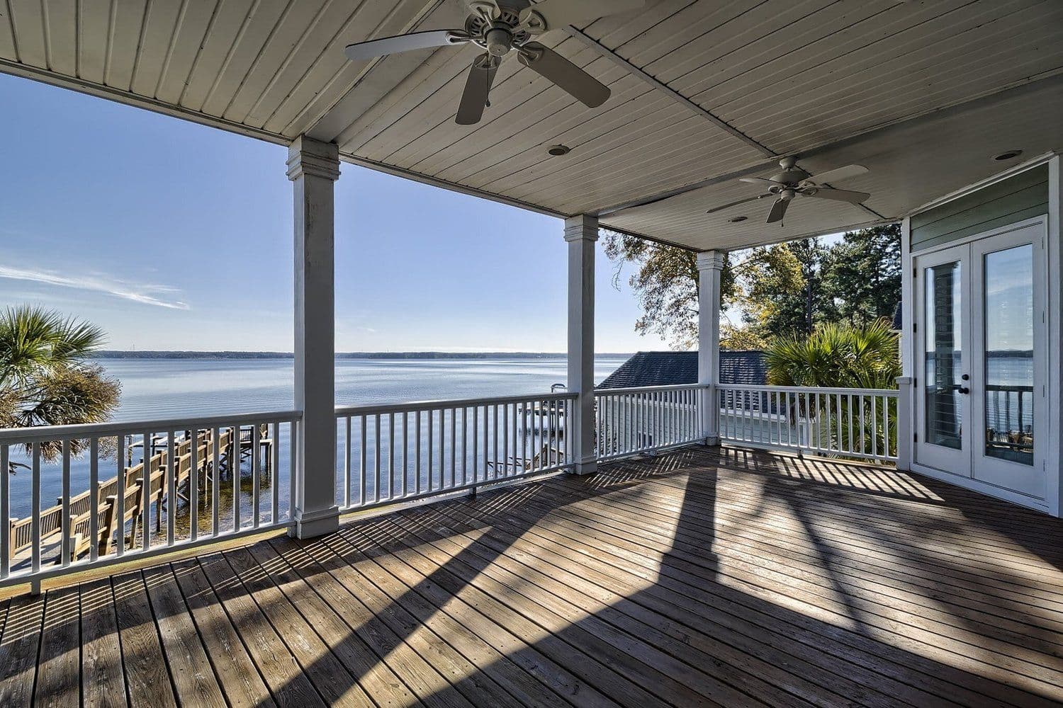 View over a calm lake from a shaded wooden porch