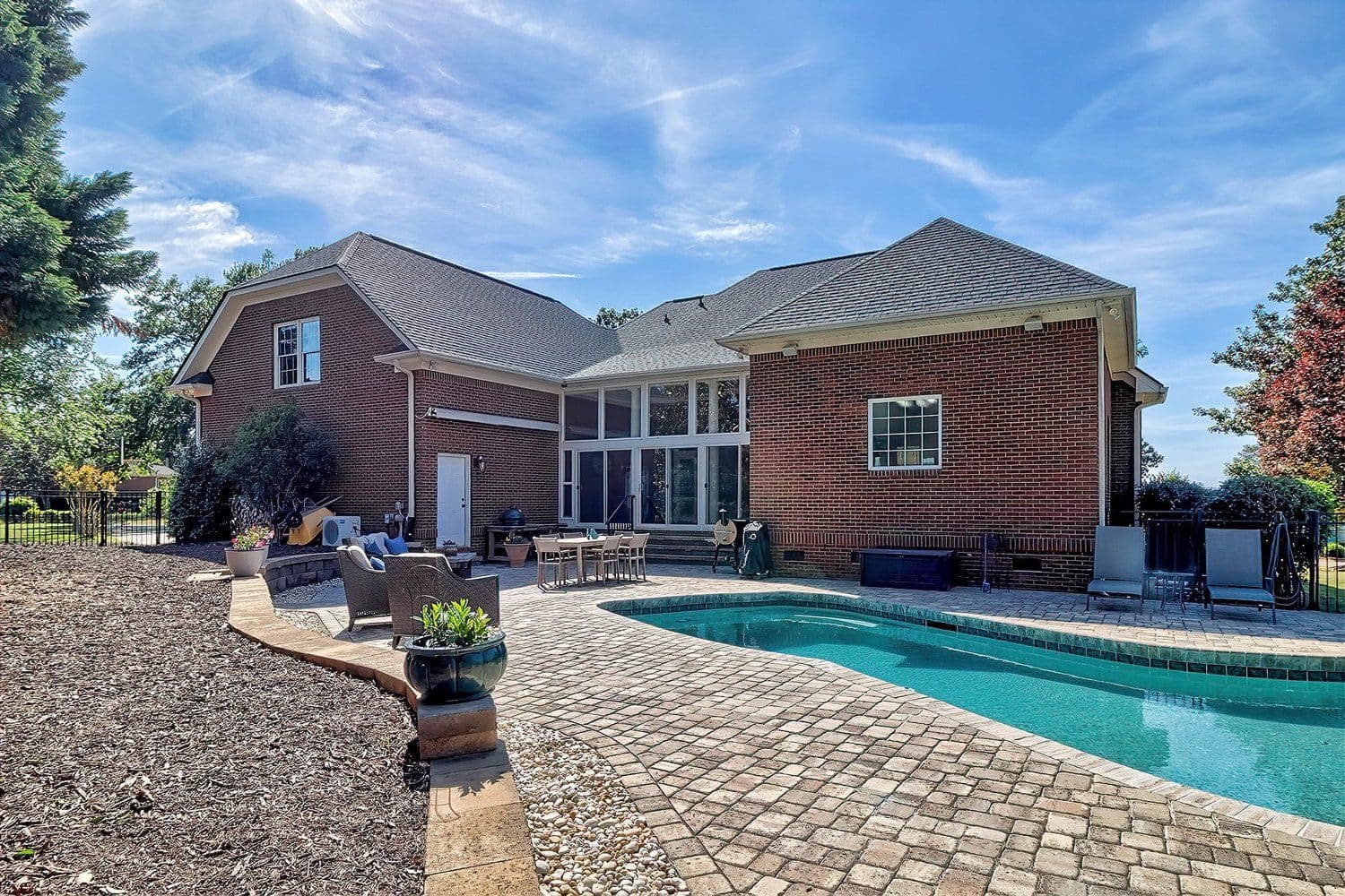Backyard pool with fire pit and brick-paved patio