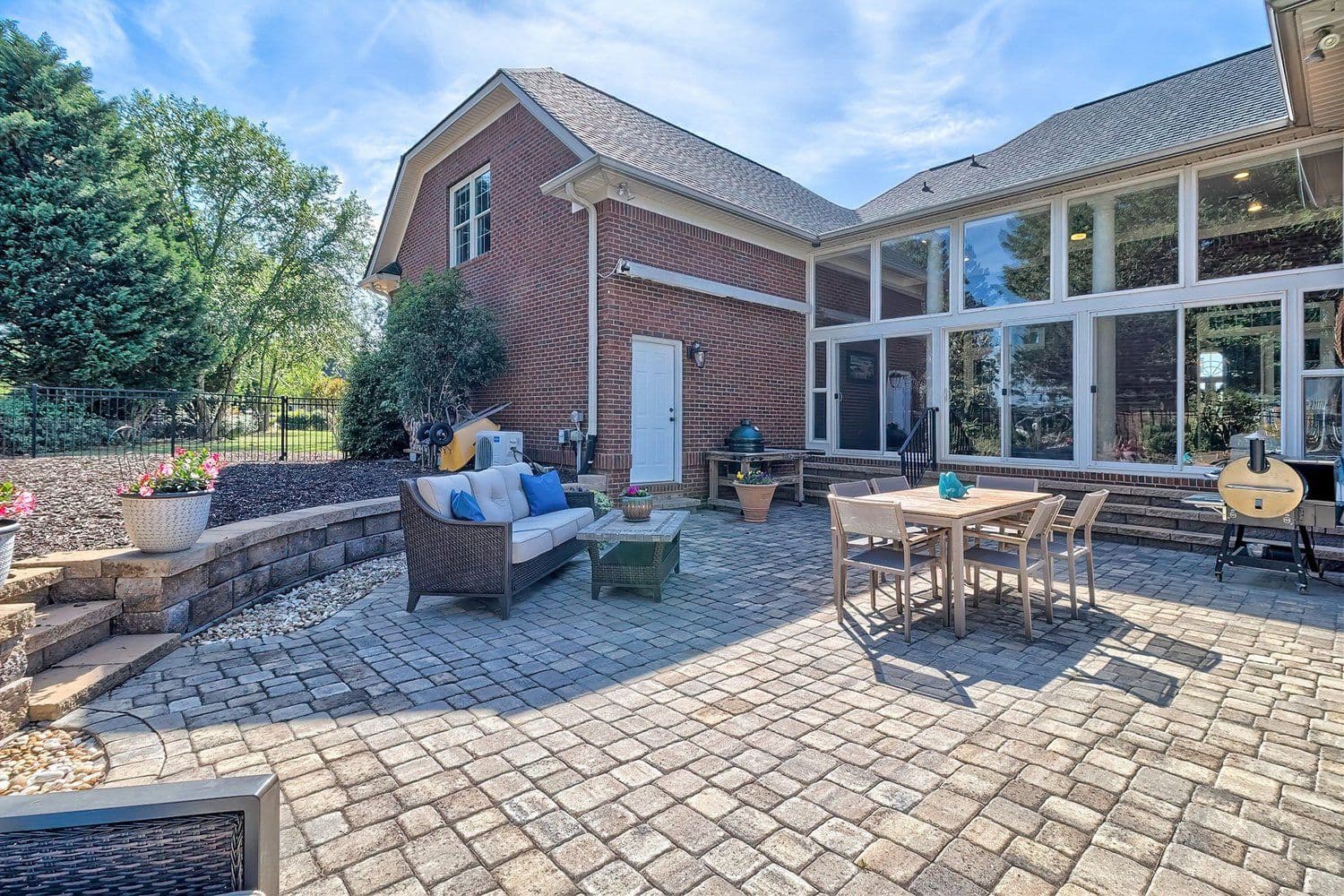 Brick home backyard with paved patio and furniture