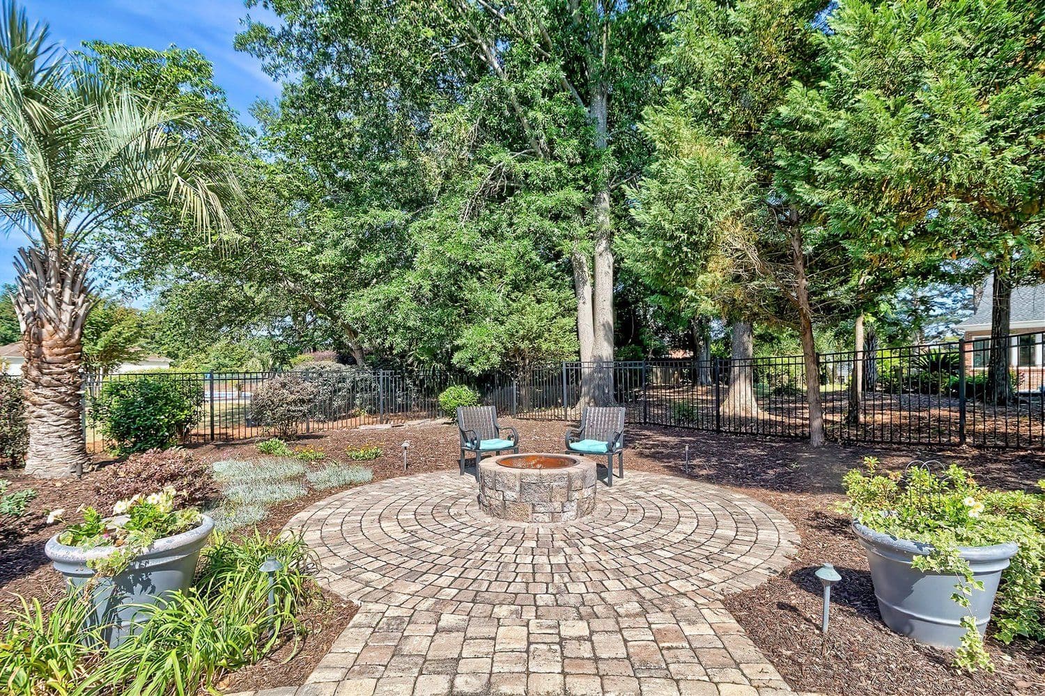 Circular brick-paved backyard patio surrounded by trees