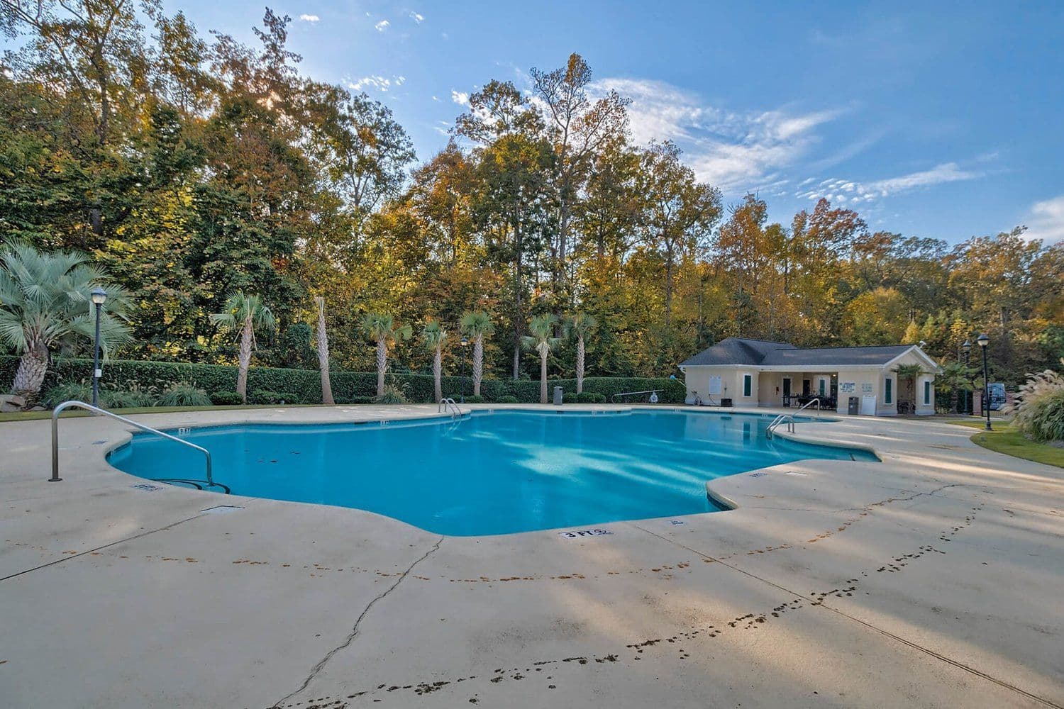 Community swimming pool with a concrete deck and pool house