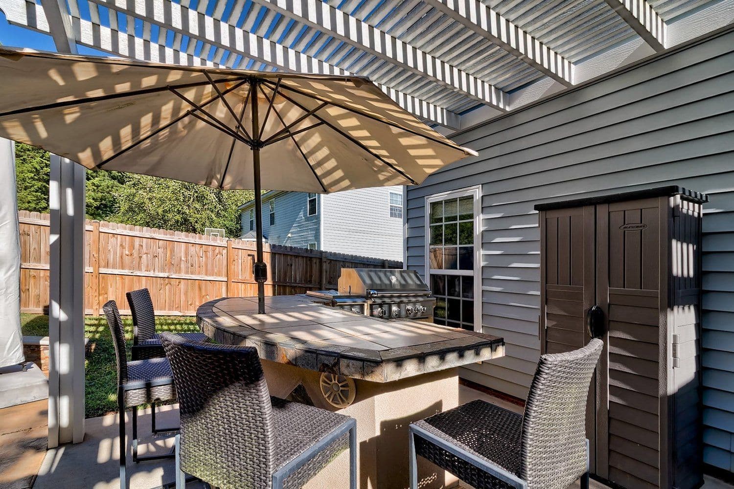 Outdoor dining area under a pergola with a large umbrella