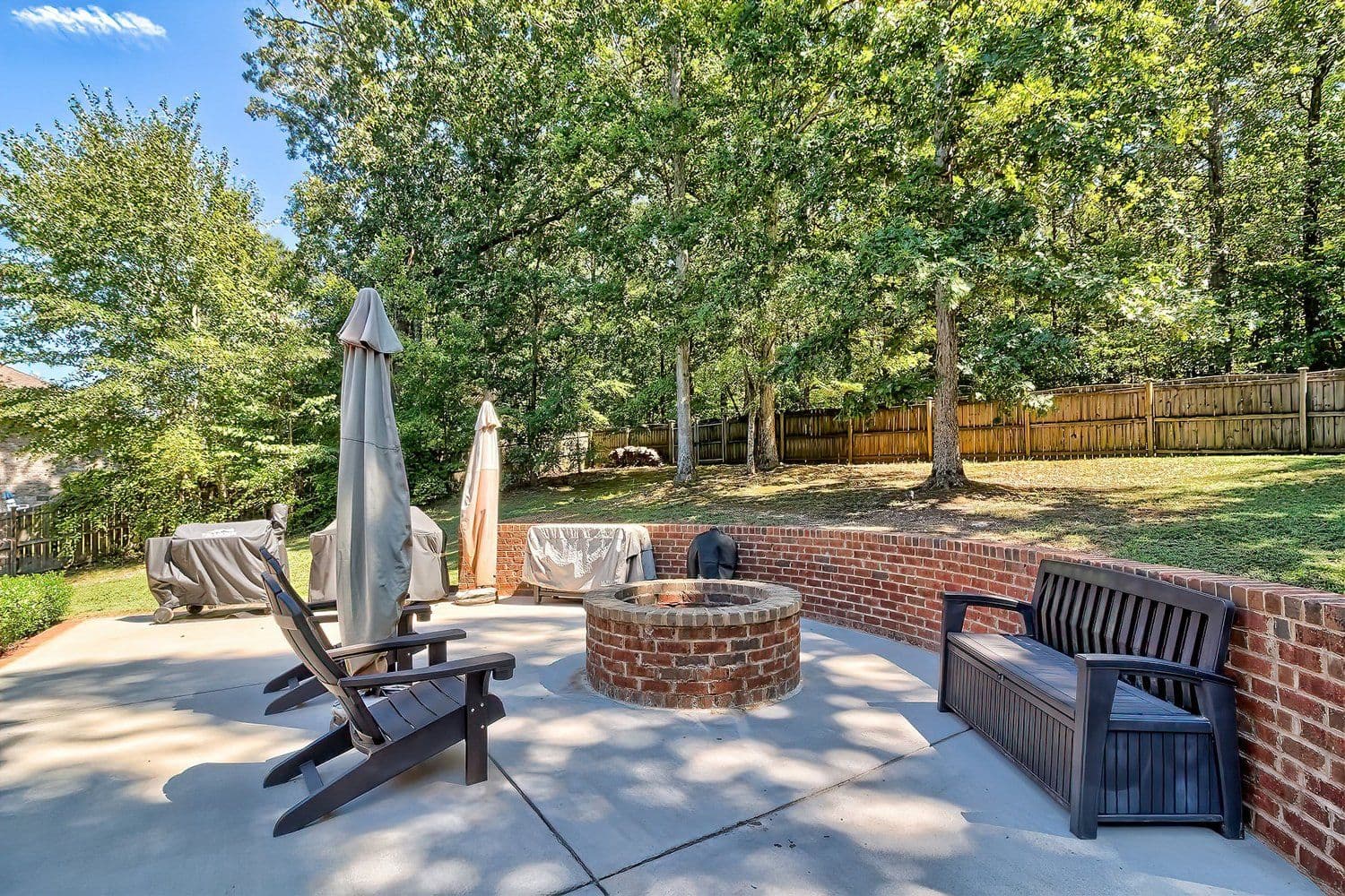 Patio with stone fire pit, Adirondack chairs and a bench