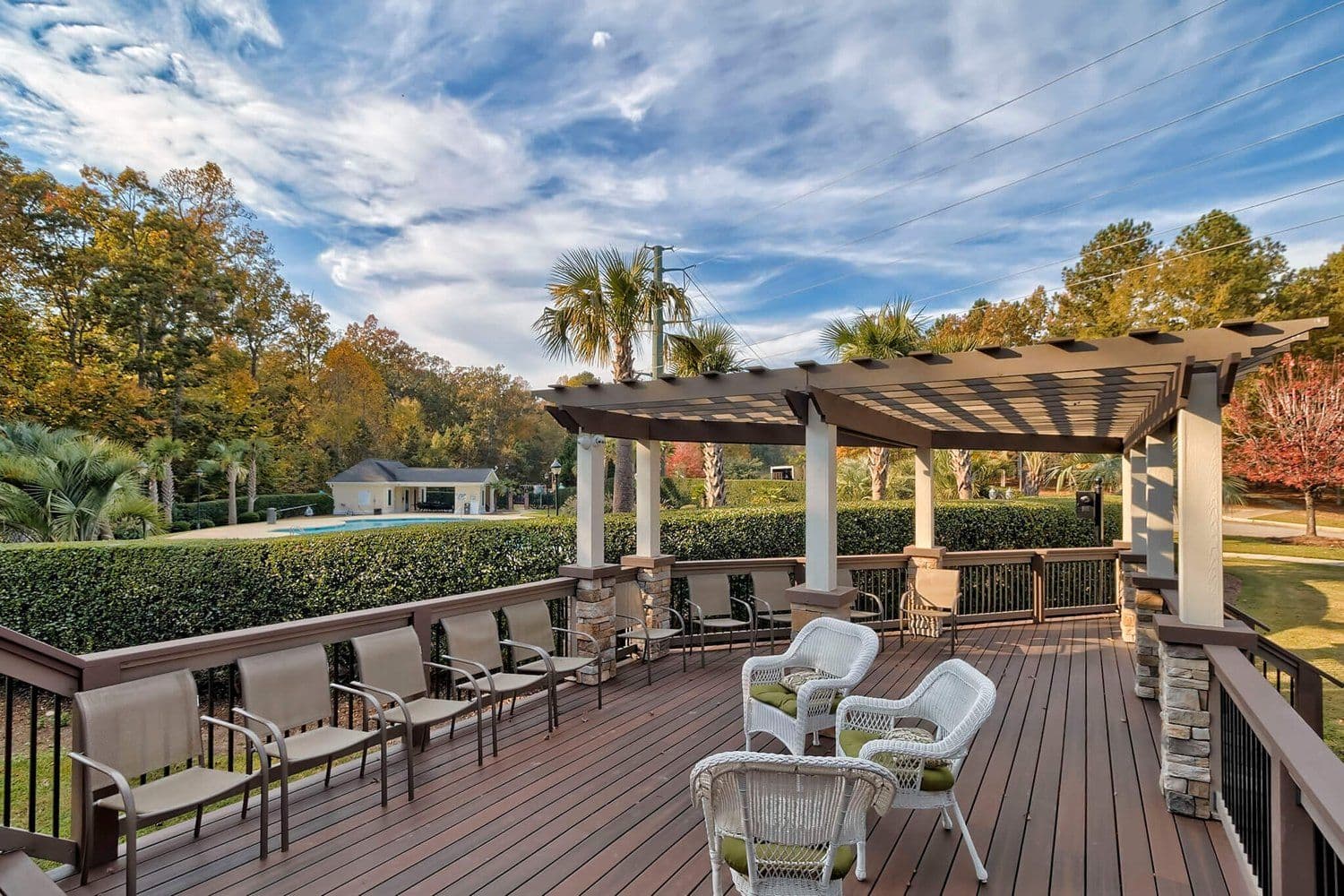 Wooden outdoor deck with a pergola overlooking green woods