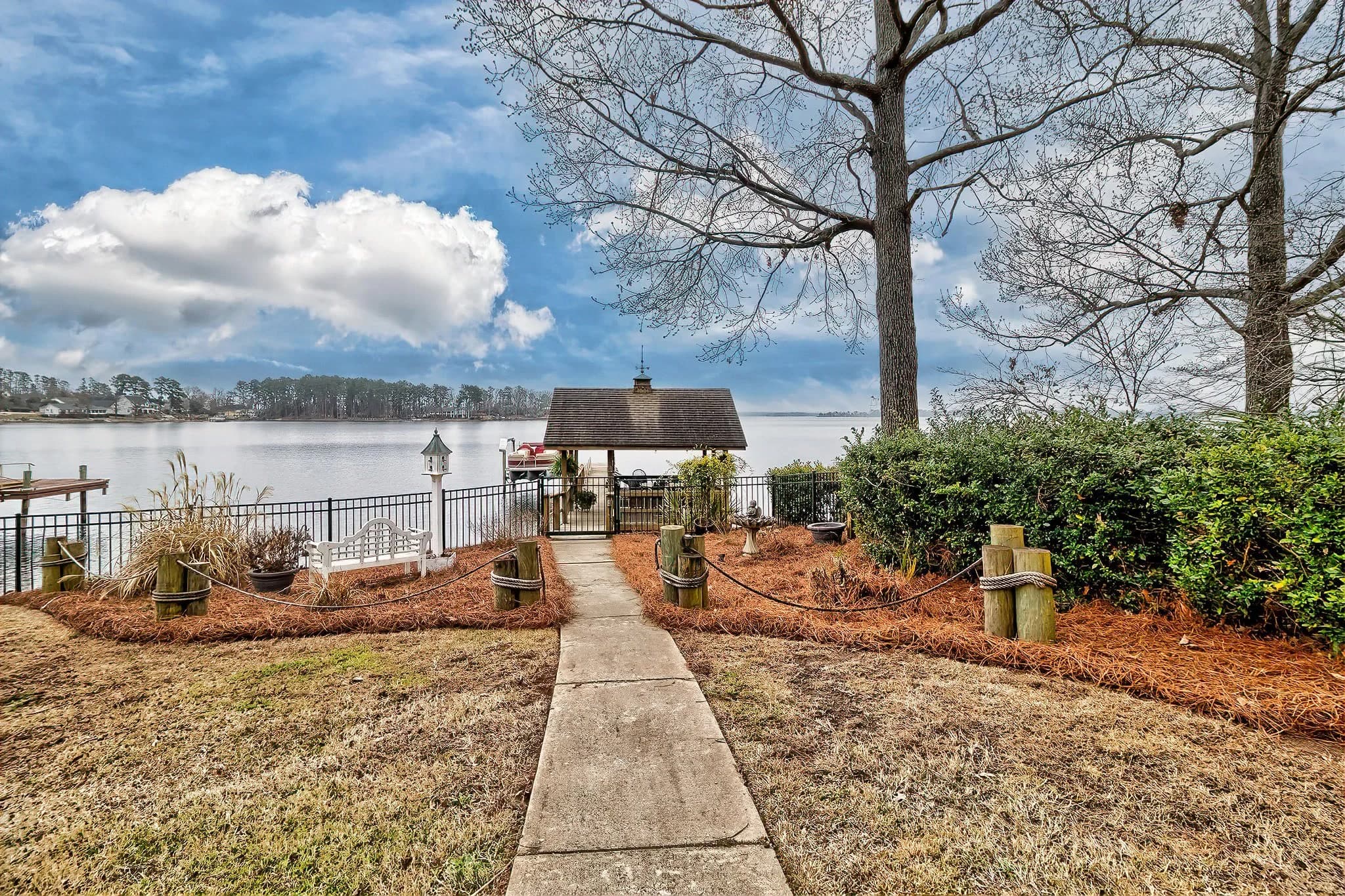 A walkway through a lawn leading to a covered dock