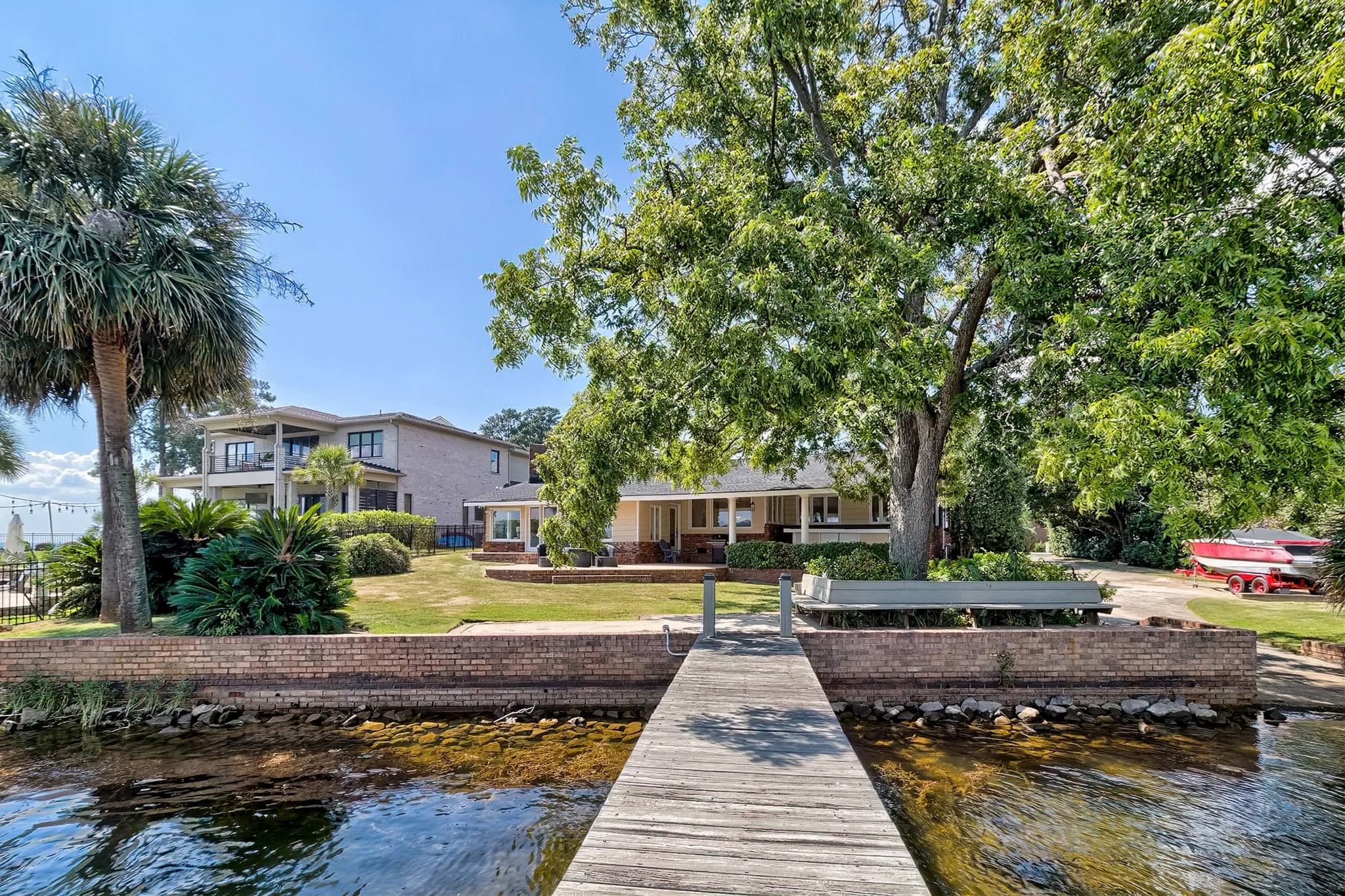 A dock looking toward a lawn with palm trees