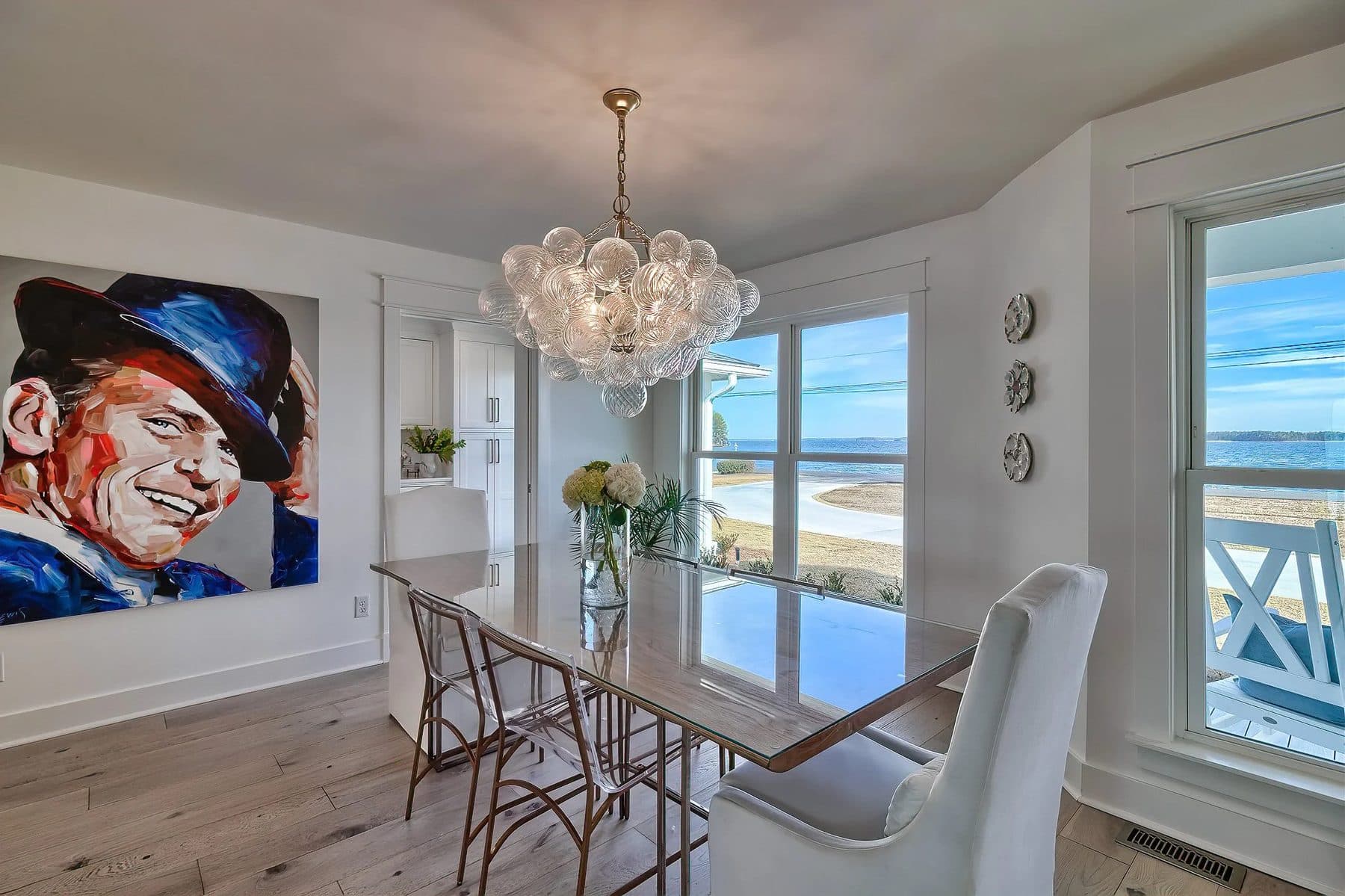 A dining table in front of windows looking at the lake
