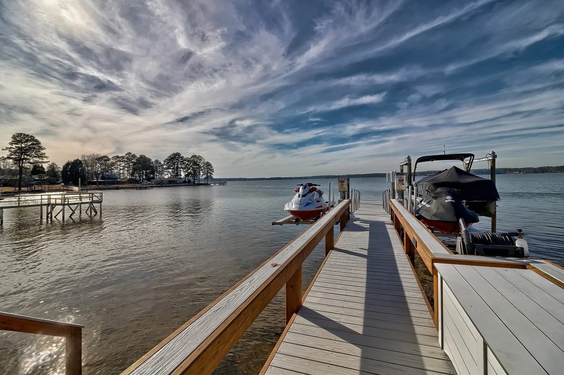 A covered dock with boat lifts on the lake