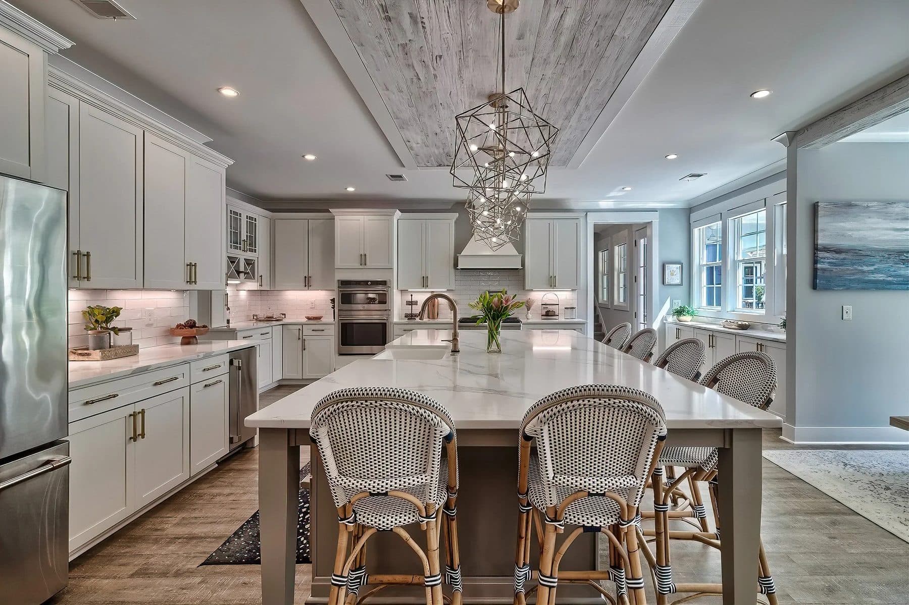 A kitchen with light cabinets, gold hardware, and an island