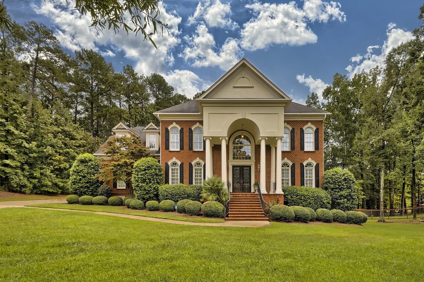 A red brick house with a white-columned portico