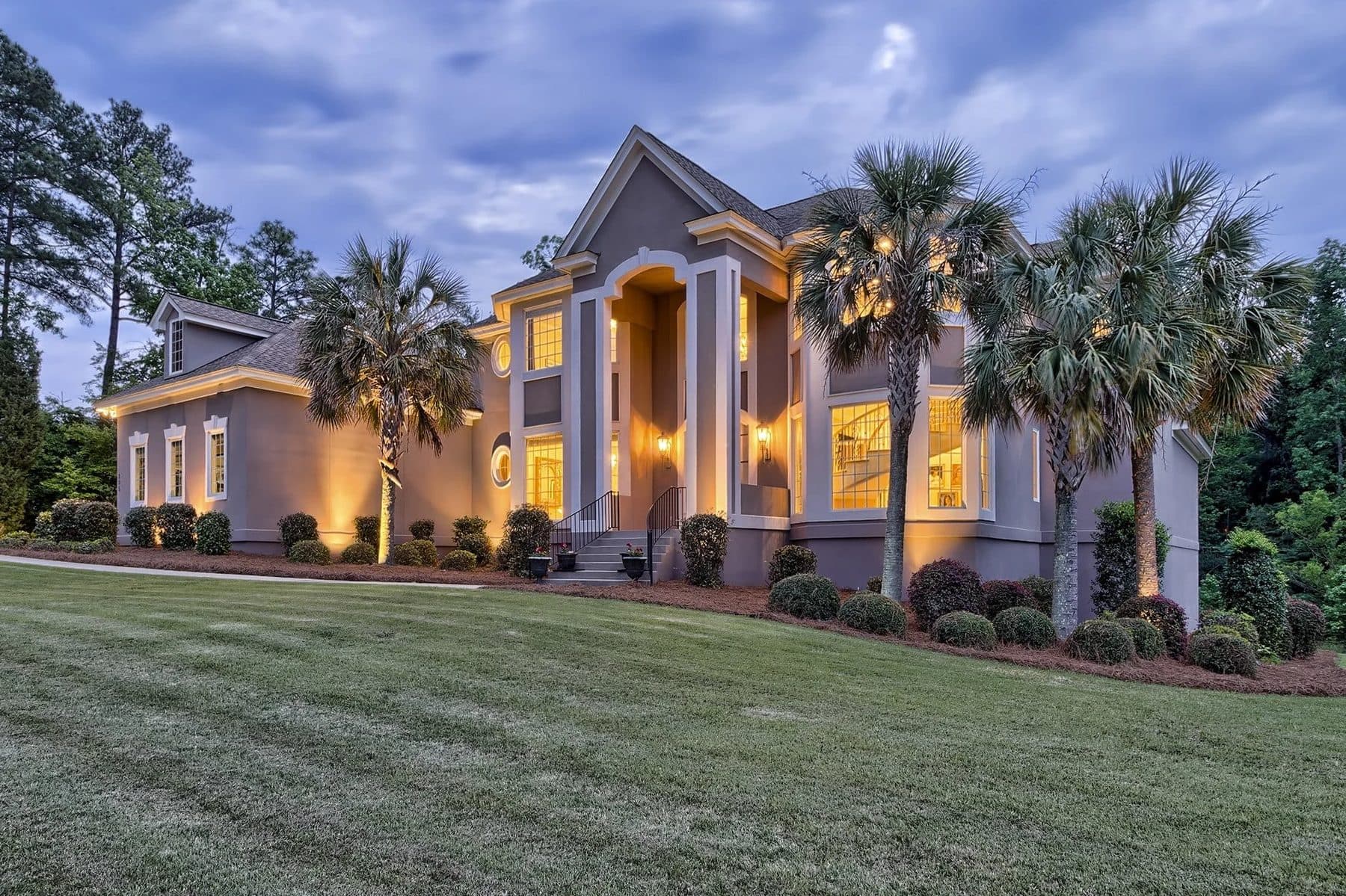 A stucco house with warm lights at dusk